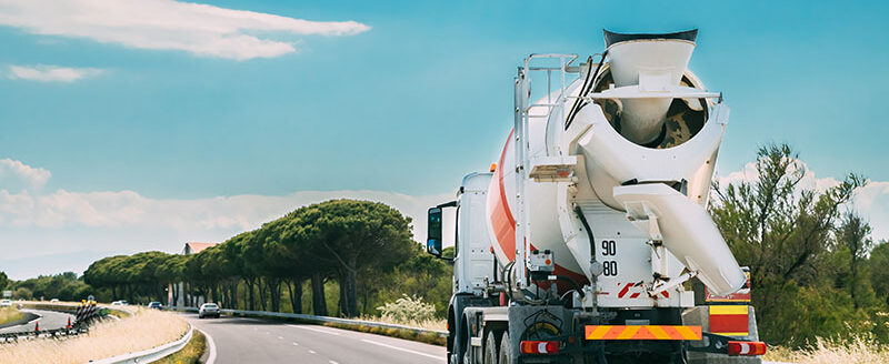 Special Concrete Transport Truck In-transit Mixer Unit In Motion On Country Road, Freeway. Freeway Motorway Highway. Business Drive Transportation And Development Concept. Concrete Truck Mixer